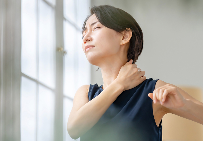 首の痛みに悩む女性