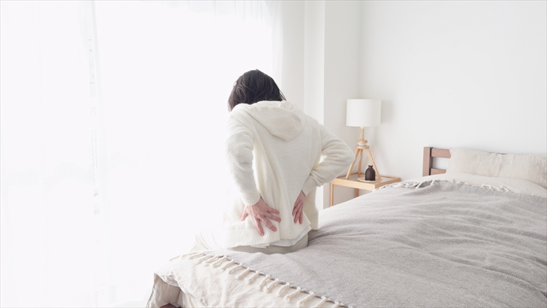 腰を抑える女性